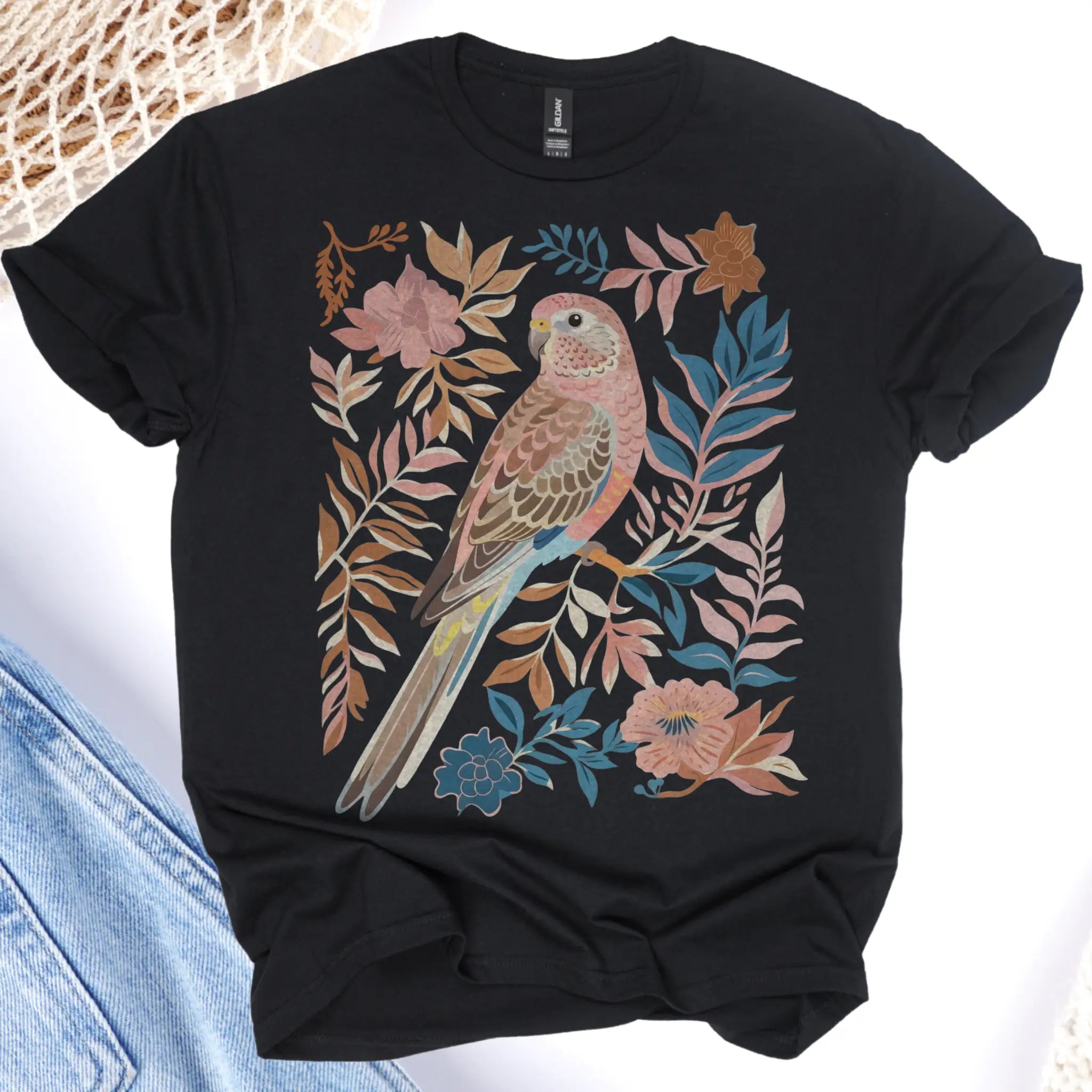 Black t-shirt with a colorful bird and leaf design on a white background