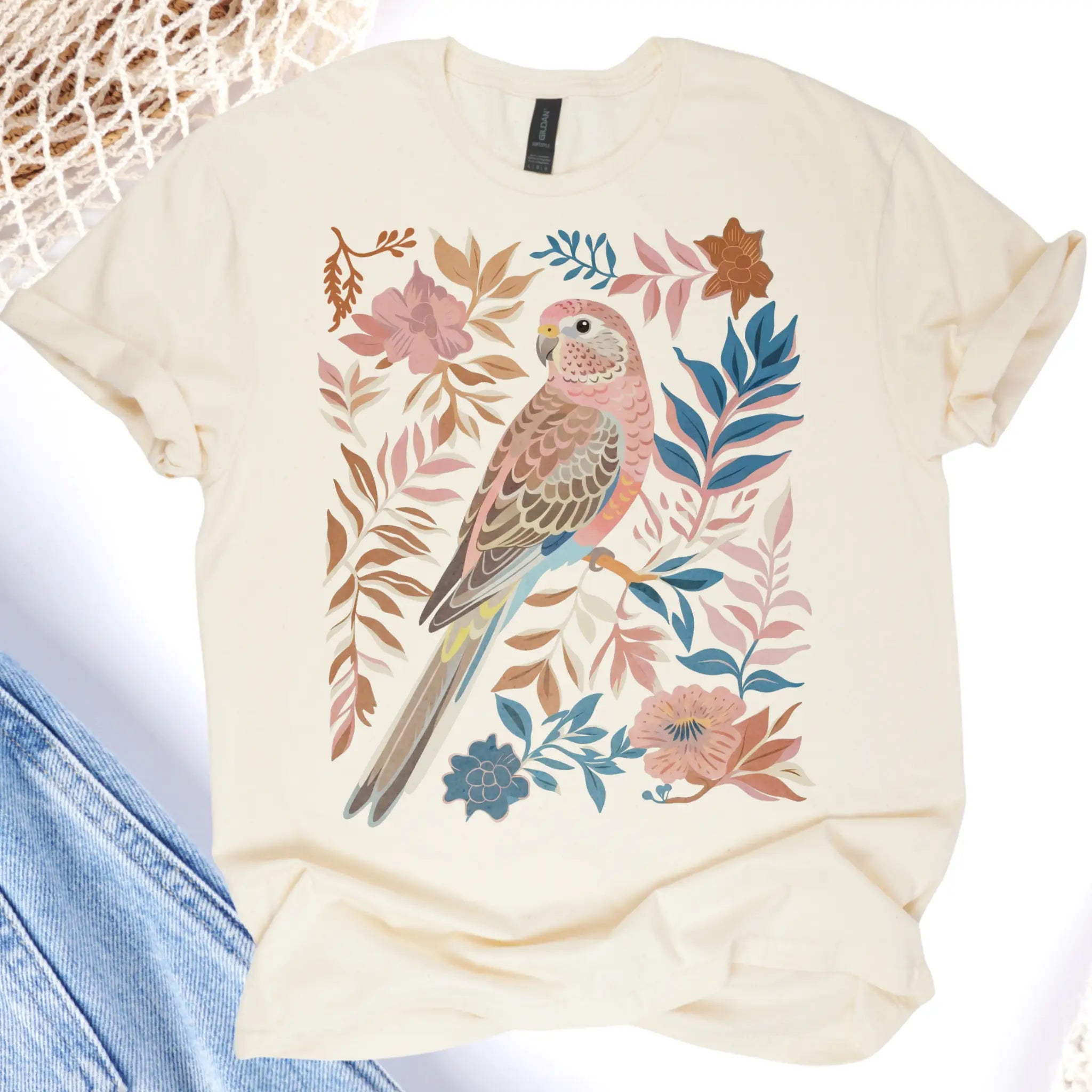 Beige t-shirt with a parrot and floral design on a white background