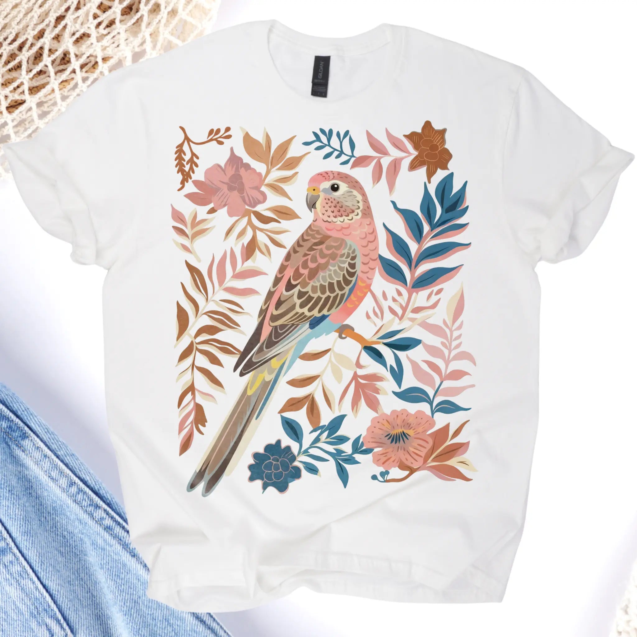 White t-shirt with a pink parrot and floral design on a white background
