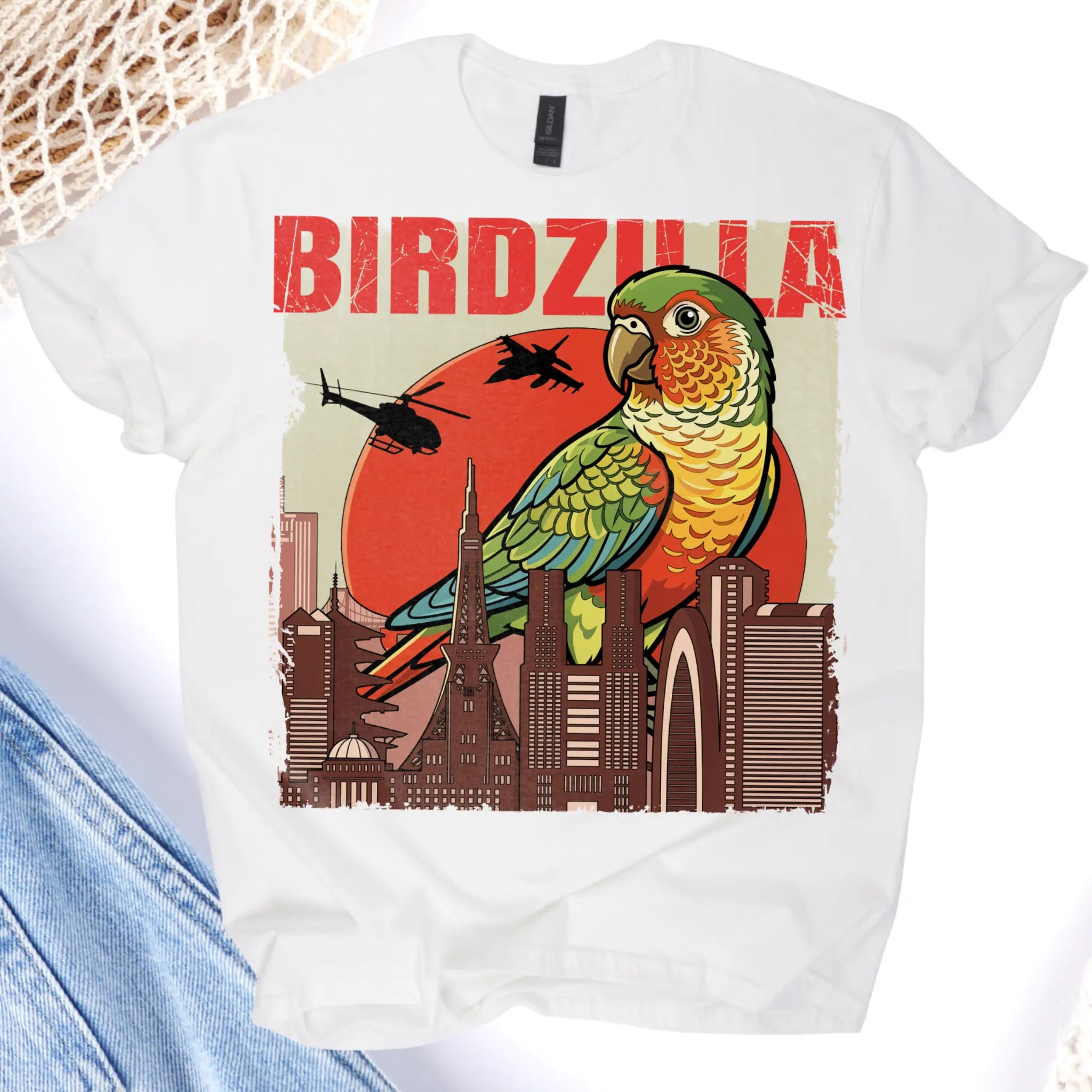 White t-shirt with a colorful parrot graphic and 'BIRDZILLA' text on a cityscape background.